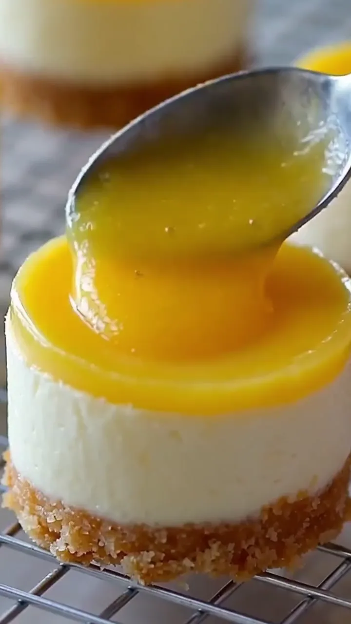 Lemon curd spooned over chilled mini cheesecakes